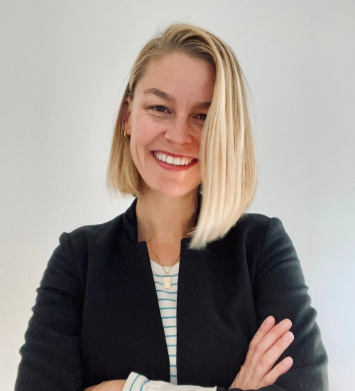 Amy Nielsen a woman smiling with her arms crossed